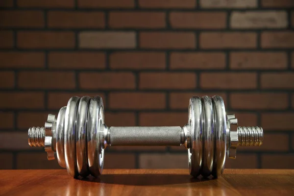 Iron dumbbells on brick wall background — Stok fotoğraf