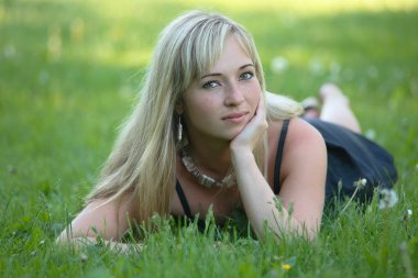 Yeşil çimlerin üzerinde genç bir kızın portresi