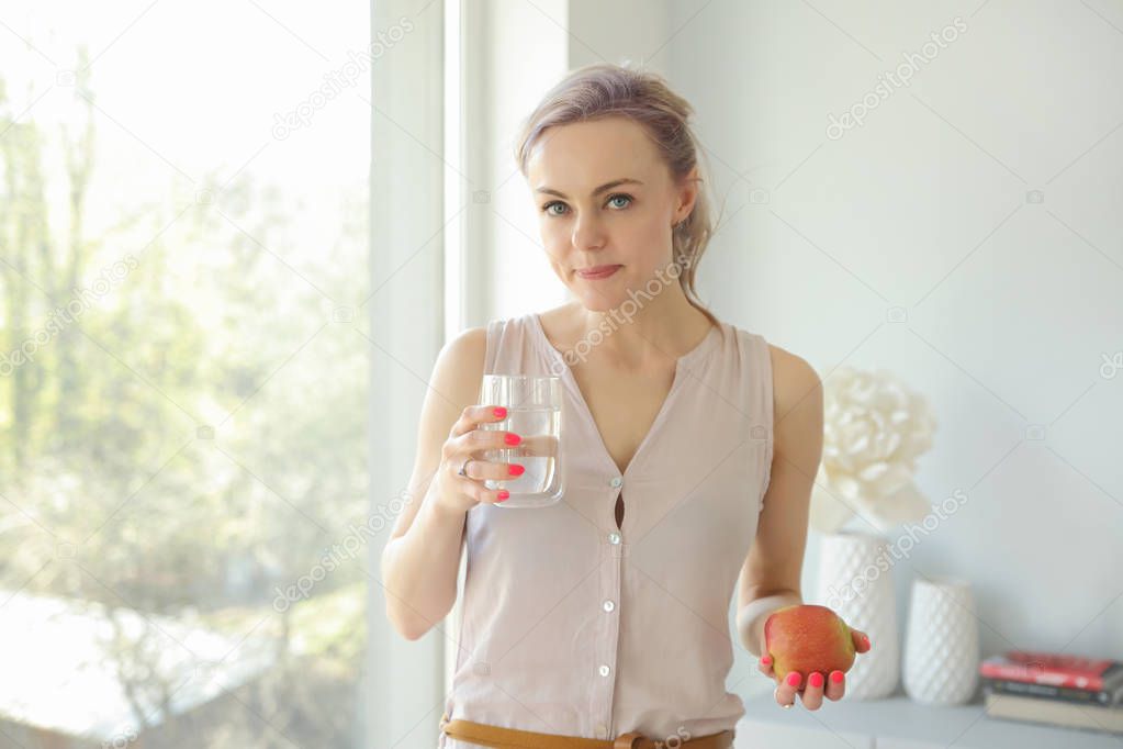 young woman with apple and glass of water