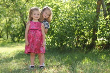 İki küçük kız kardeş bahçede eğleniyor..