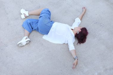 Beyaz bluzlu ve mavi pantolonlu kadın.