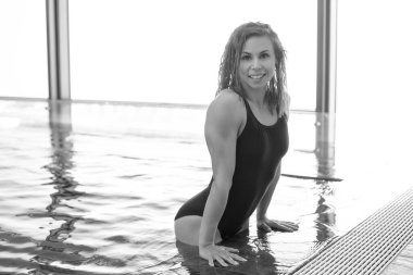 Havuzda mavi mayolu, gülümseyen atletik kız.