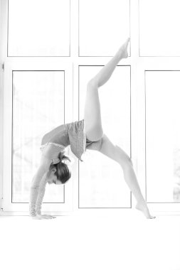 Mayo giymiş atletik kadın pencerede poz veriyor.