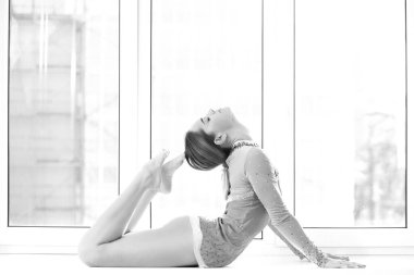 Mayo giymiş atletik kadın pencerede poz veriyor.