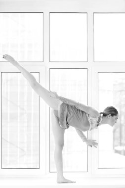 Mayo giymiş atletik kadın pencerede poz veriyor.