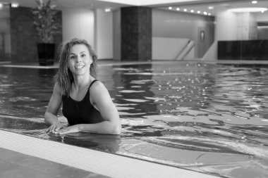 Havuzda mavi mayolu, gülümseyen atletik kız.