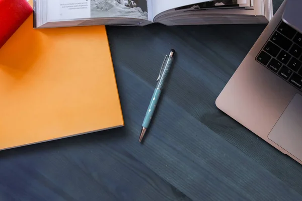 Image of a university student\'s desk with books, notebooks and stationery to study