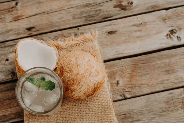 Coconut water. Fresh and delicious coconut water. wood and green background.