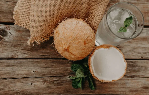 Coconut water. Fresh and delicious coconut water. wood and green background.