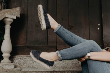 Ayakkabı ve sandalet giyen, dışarıda modellik yapan bir kadın.