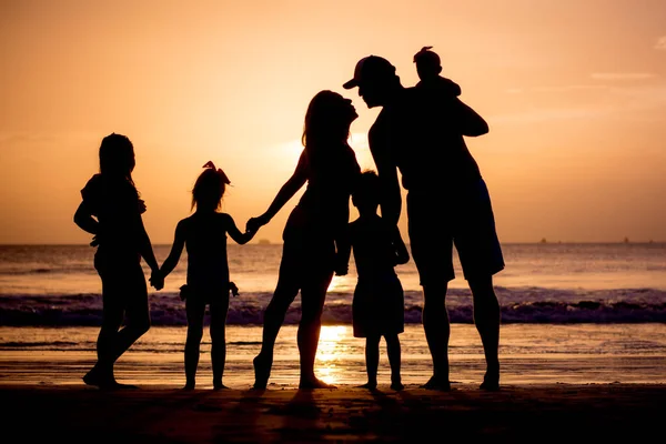 Aile silueti gün batımı kumsalında.