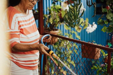 Bahçeyi sulayan yaşlı kadın..