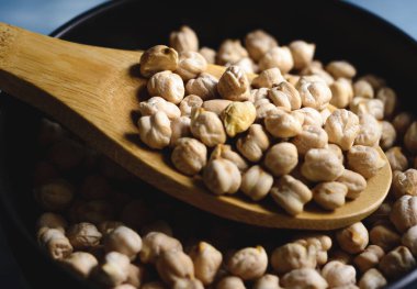 Kavanozda çiğ nohut ve odun kaşığı.