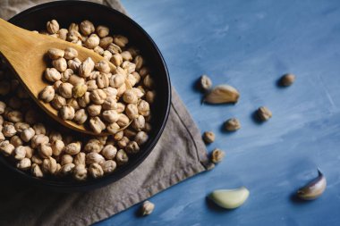 Kavanozda çiğ nohut ve odun kaşığı.