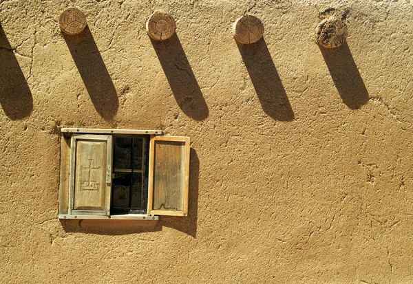 Fönster i en byggnad från adobe. Stockbild