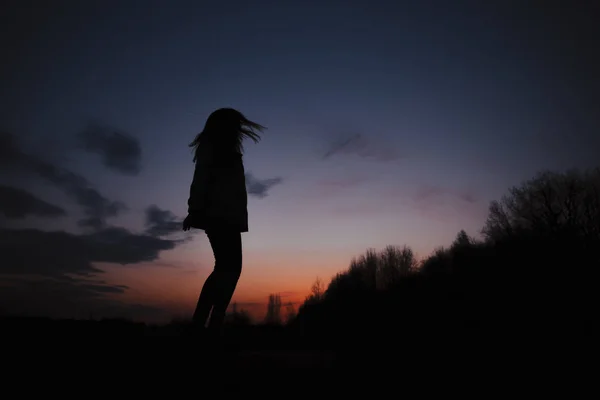 Günbatımı arka planında kız siluetleri