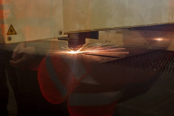 Industrielaserstrahl schneidet Stücke brillanten Metalls — Stockfoto