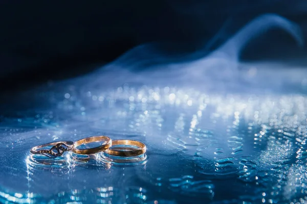 Cincin pernikahan. Tiga cincin emas: cincin pertunangan dan cincin pertunangan di cermin. — Stok Foto