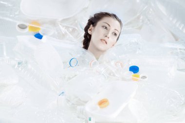 Plastik bir denizde bir adam boğuluyor. Kızlar farklı tipte plastikler arasında batar..