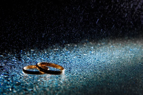 Anéis de casamento clássicos em uma gota de água . — Fotografia de Stock