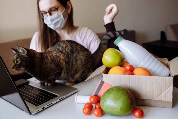 Ön planda bir kutu sipariş edilmiş yiyecek var. Arka planda, kız dükkandan bir yemek yiyor.. 