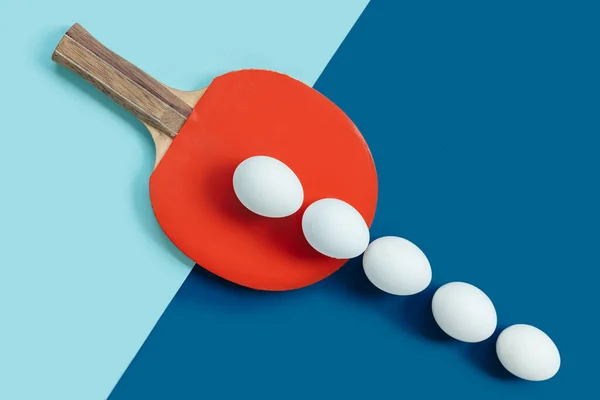 Kırmızı masa tenis raketinde beyaz yumurtalar var. Beyaz yumurtalar sıraya dizilir ve çizginin dışına çıkar.. — Stok fotoğraf