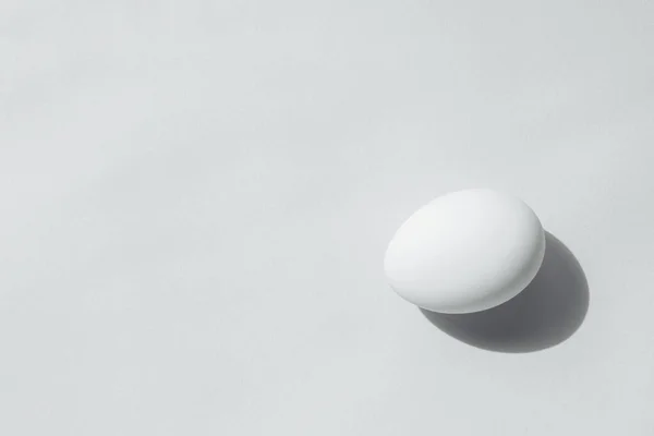 Çerçevenin kenarında beyaz bir yüz var. Yumurta düzenli ve güzel bir şekildir. Sağda da bir gölge var.. — Stok fotoğraf