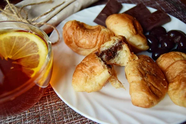 Kruvasanla kahvaltı, limonlu çay ve güzel bir peçete. Seçici odak yazarının fikri.