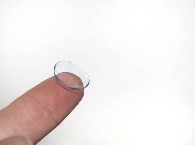 parmak, beyaz arka planda kontak lensleri tutar..