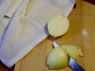 Arka planda tahta bir tahta üzerinde yarım doğranmış taze soğan yakın plan beyaz bir havlu. seçici odak.