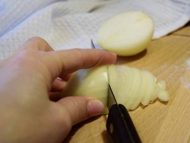 Arka planda tahta bir tahta üzerinde yarım doğranmış taze soğan yakın plan beyaz bir havlu. seçici odak.