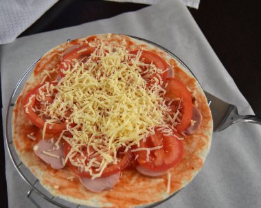 Pizza pişirme işlemini evinizin mutfağında yapıyor. Kapat.