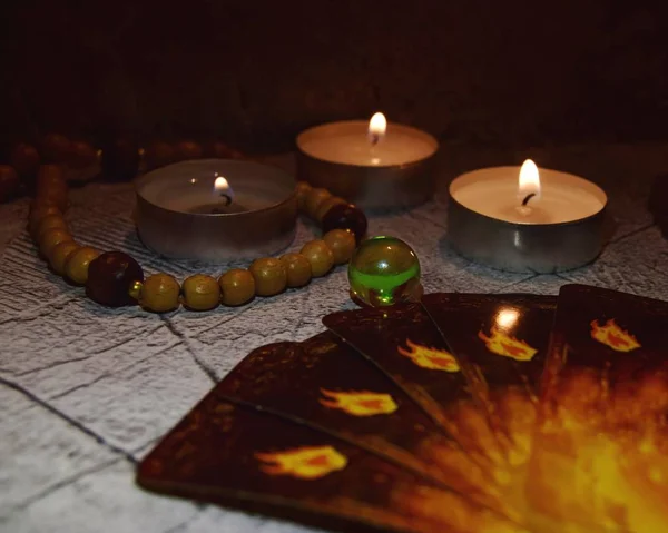 Mistik durgun hayat. Yakıcı mumlar, sihirli cam bir top ve karanlık bir arka planda kartlar. Kehanet kavramı, kehanet kavramı. Sihirli kristal küre ve kartların tahminleri. seçici odak