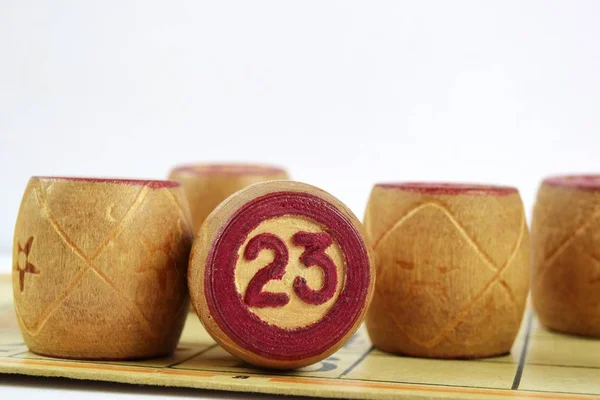 23 numaralı ahşap loto fıçıları. Beyaz bir arka planda izole edilmiş. Aile tombalası oyunu. Kavramsal fotoğraf.