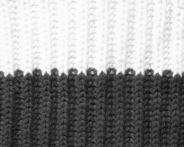 knitted wool background in two colors black and white. elastic band binding texture one front one wrong