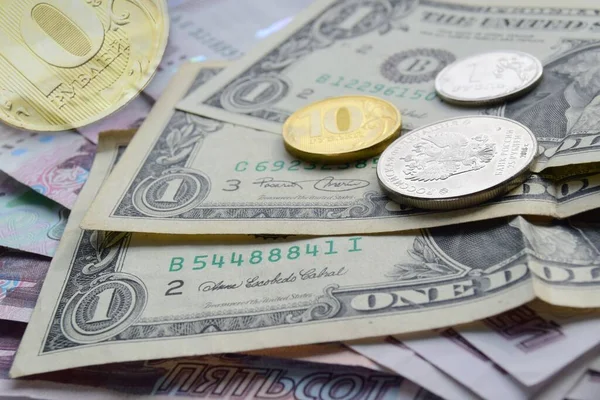 Banknotlar Amerikan dolarlarıyla Rus kağıt rublelerinin üstüne yerleştiriliyor, üstünde de madeni paralar var. Finansal kriz ve tasarruf için para seçimi, Rublonun devalüasyonu konsepti.