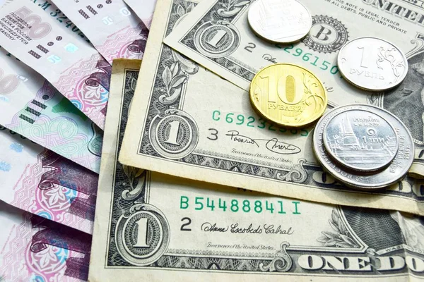Banknotlar Amerikan dolarlarıyla Rus kağıt rublelerinin üstüne yerleştiriliyor, üstünde de madeni paralar var. Finansal kriz ve tasarruf için para seçimi, Rublonun devalüasyonu konsepti.
