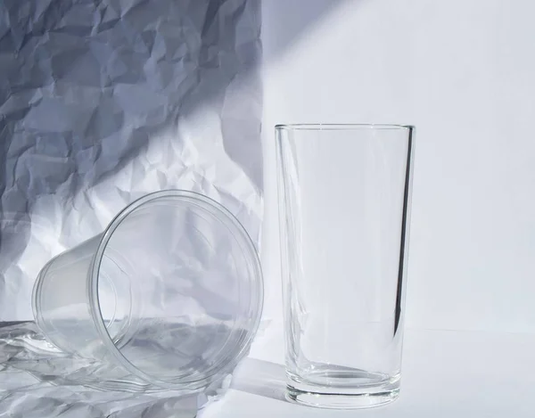 Glass or plastic cup, against a background of a plain white sheet and a crumpled white sheet. waste reduction. reusable use