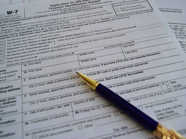 W7 tax form for American citizens, filling out a declaration and instruction. selective focus close-up.