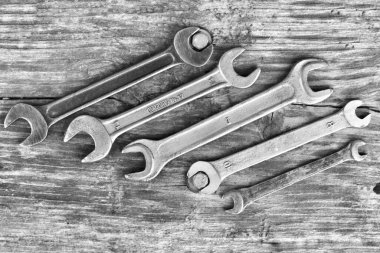 Tahta bir arka planda farklı çapta yayıcılar ve 10 siyah beyaz fotoğrafta bir cıvata.