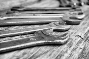 Ahşap arka planda farklı çaplı yayıcılar, siyah ve beyaz fotoğraf. Yakın plan, yumuşak odak