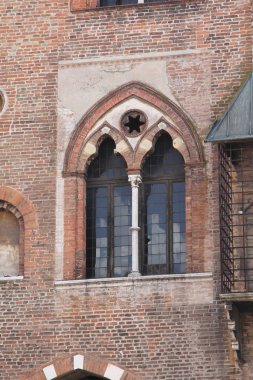 Eski tuğla duvarda ortaçağ tarzı cam pencere