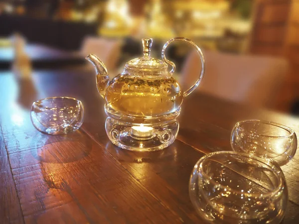 Teaszertartás - üveggyógynövény teáskanna fából készült asztalon — Stock Fotó