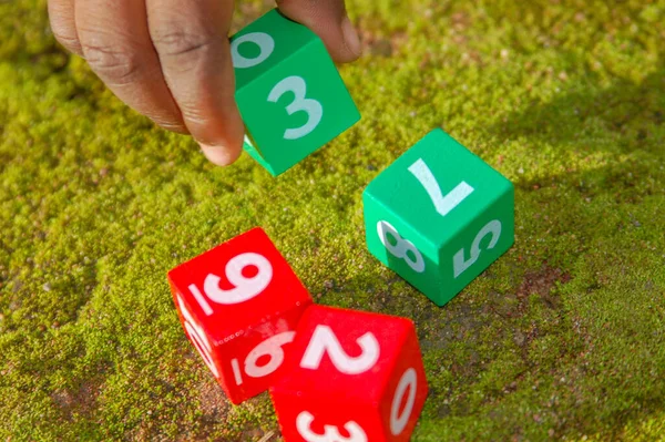 Playing with numbered block toys. Picking cubes with numbers