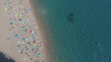 Güneşli şemsiyeli kumlu kumsal manzarası, Bali, Endonezya