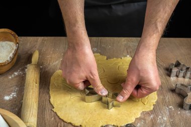 Adamın elleri kurabiyeleri kesiyor.