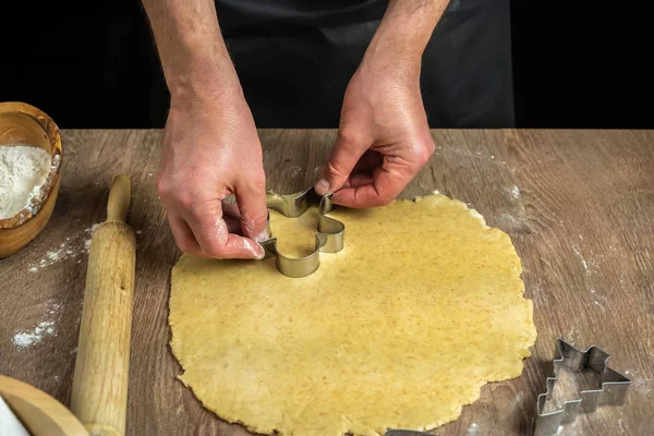 Las manos del hombre cortan galletas — Foto de Stock