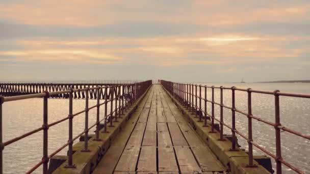 Wooden pier leading far into the sea in cloudy weather — Stock Video