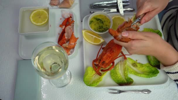 A woman cuts lobster tail with cutlery, butchering lobster, top view, 4K — Stock Video