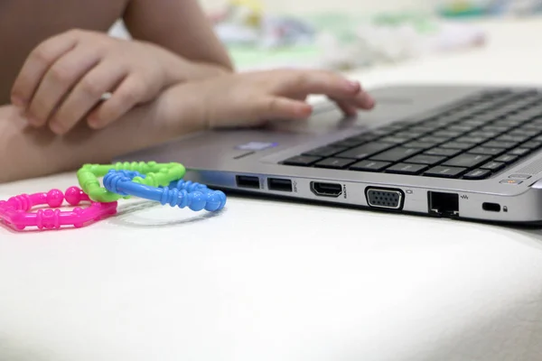 The photo was taken on December 10, 2019.The girl is making a presentation on a laptop, next to it is a baby rattle.Photo taken in an apartment in Moscow.